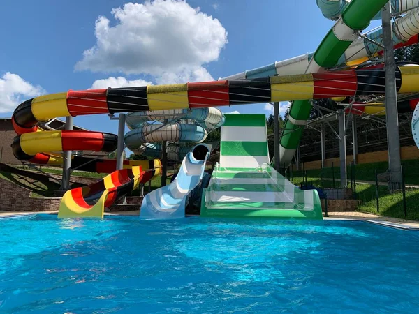 Water park slides against the blue sky. Summer Amusement Park, water attraction. Modern water park with colorful slides.