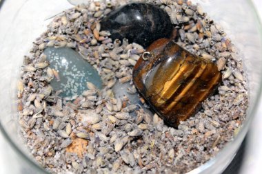 Lavanta tohumları arasında bir kaptaki yarı değerli taşlar.