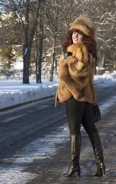 Привлекательную женщину в лисьей шубе фотографируют зимой — стоковое фото