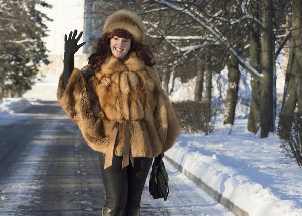 De aantrekkelijke vrouw in een vos bontjas is gefotografeerd in de winter Stockfoto