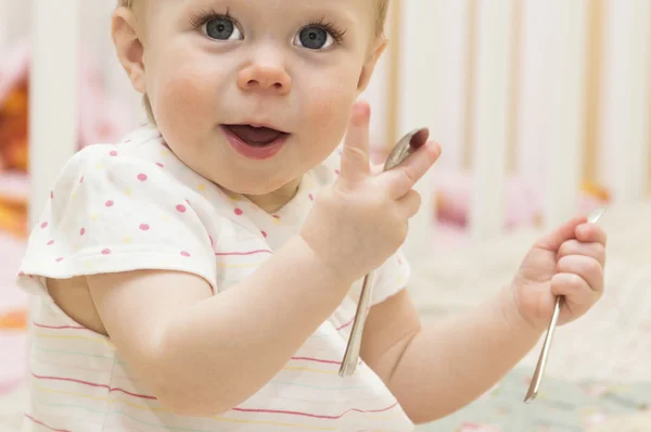 De baby speelt met lepels. — Stockfoto