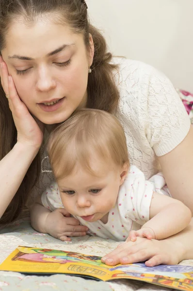 De moeder leest het boek aan de baby. — Stockfoto