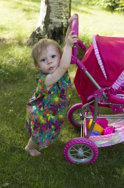 Ragazza di 1 anno cammina in un giardino . — Foto Stock