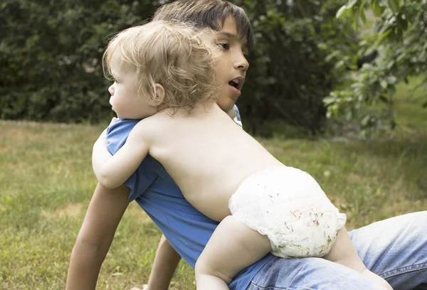 Outdoor portrait of the baby and teenager. — Stock Photo, Image