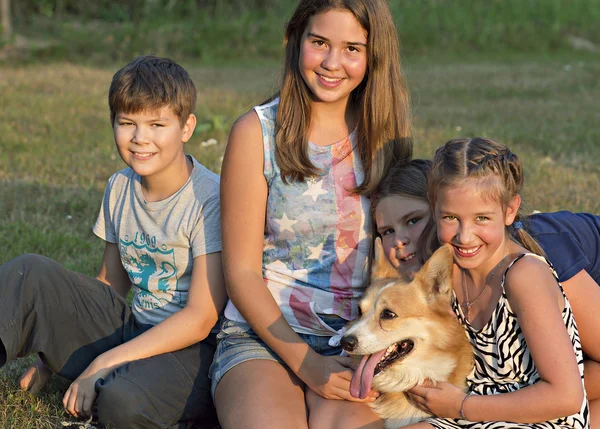Outdoor portrait of group of teenagers with the dog. Stock Picture