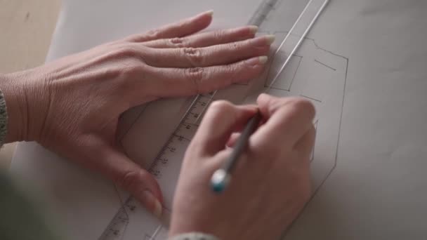 閉めろ 鉛筆を持っている女性の手は大きな紙の上に線を描く 定規と鉛筆で画家がポスターを描く — ストック動画
