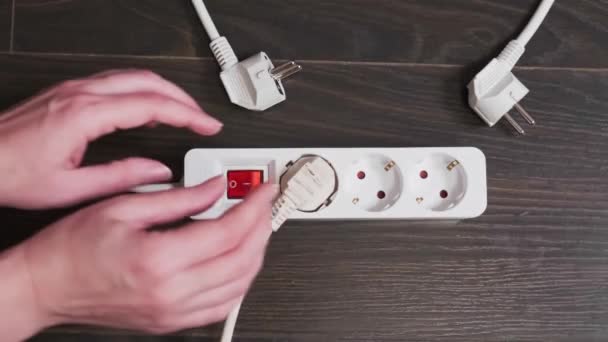 Close Female Hands Turns Plug Out Socket Power Strip Floor — Vídeo de Stock