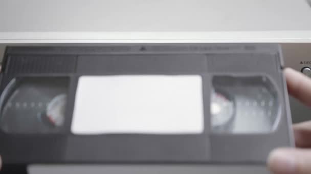 Vhsビデオカセットはビデオを見るためにVcrに置かれる ビデオテープのクローズアップ — ストック動画