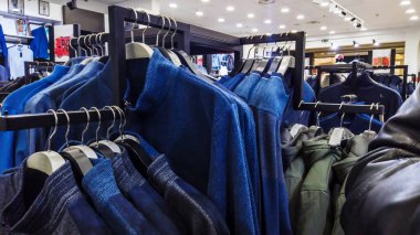 Satıştayken giyim mağazası. Askıda farklı kıyafetler..