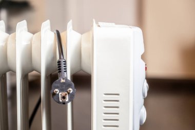 Modern yağ ısıtıcısını kapattım. Kablolu fiş ısıtıcının üzerine atıldı..