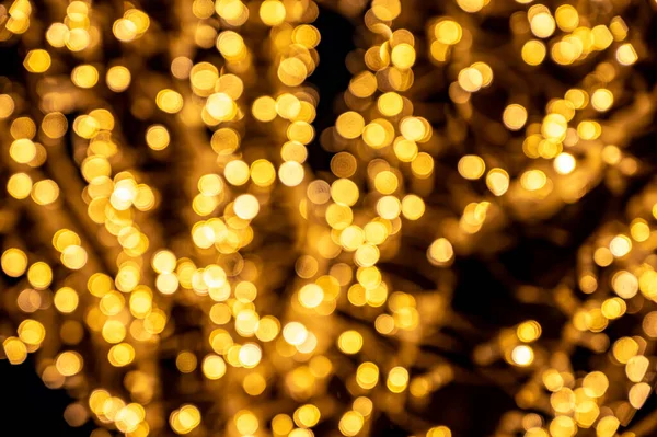 Soyut sarı çözünmüş arka plan. Karanlık gece küçük yuvarlak ampullerle aydınlatıldı. bokeh etkisi