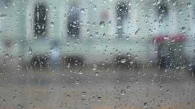 Bir pencerenin şeffaf camından süzülen yağmur damlalarına yakın çekim