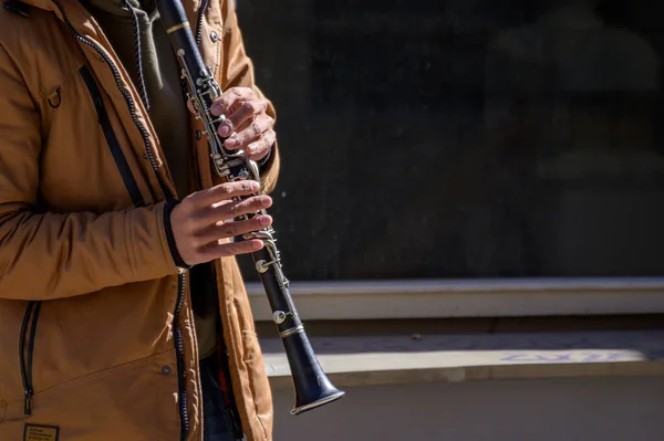 Male musician playing the clarinet on the street. Street musician.