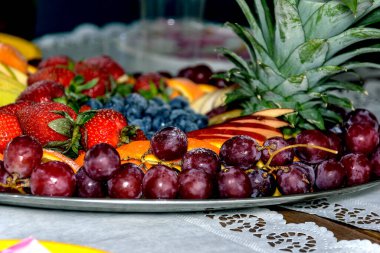 Çiğ böğürtlen ve meyve, üzüm, çilek, yaban mersini, greyfurt, ananas, masada beyaz bir tabakta elma, seçici odaklı görünüm