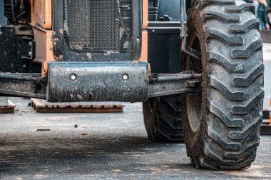 Traktörün bir kısmı süspansiyon ve şok emici sistemi gösteriyor, aynı zamanda büyük ön lastiği de..