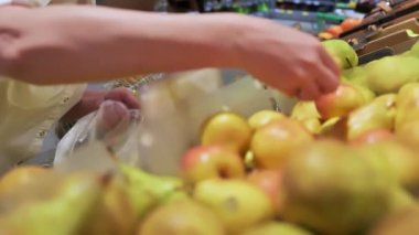Kadın kırsal kesimdeki marketten taze elma seçiyor. Yakın plan el..