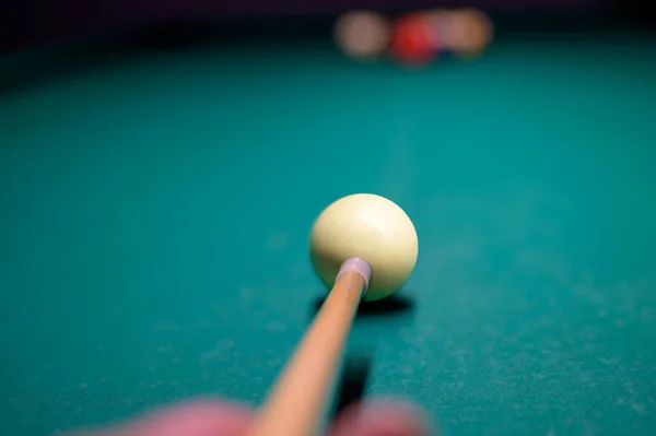 Bilardo oyuncusunun eli kiminle ve top bilardo masasında. Snooker, bilardo topuna nişan alan biri.