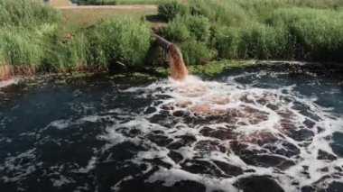 Borudan kirli kanalizasyon akıyor, endüstriyel atıklar, insan yapımı çevre kirliliği.