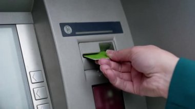 ATM 'de kredi kartı olan bir kadın eli. Bir kadın kredi kartıyla ATM kullanıyor..