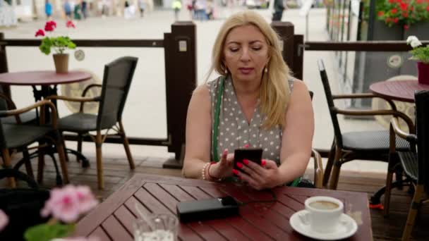 Woman Charges Her Phone External Battery While Sitting Outdoor Cafe — Vídeos de Stock