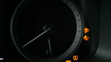 Close-up of a tachometer and fuel gauge in a car. The instrument panel lights up.