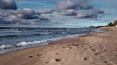 Baltic Sea with sandy shore and sand dunes. Dramatic sky with glowing clouds. Idyllic seascape.