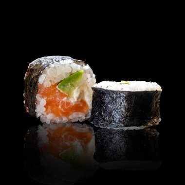 Menü için siyah arka planda somonlu klasik suşi rulosu. Asya yemekleri.