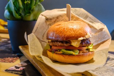 Biftek, yumurta ve domuz pastırmalı burger bir kafede servis edilir. Tahta bir masada nefis bir gurme..
