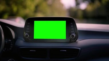 Close up display with green screen on car panel, car driving with navigation concept, blank screen dashboard.