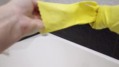 cleaning woman takes off yellow protective gloves, first person view.