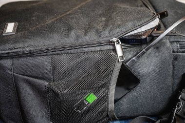 Akıllı telefon, yanında sırt çantasında duran güç bankasından şarj edilir. Modern teknoloji kavramı