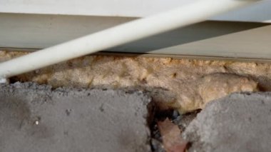 DIY. Filling with mounting foam between the window space for energy saving. Keep your home warmer through insulation. Close up