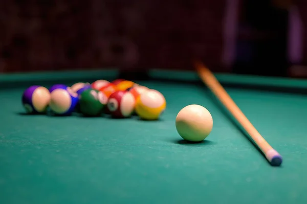 Billiard pool game, colored balls with cue stick and cue ball set on billiard table with green cloth