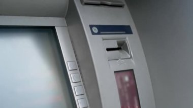 Para çekme ATM 'si. Kadının eli bankamatiğe plastik kredi kartı sokuyor. Görüntüyü kapat