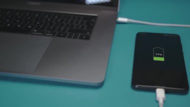 USB kablosuyla laptopa bağlı yakın çekim telefon. akıllı telefon şarj konsepti.