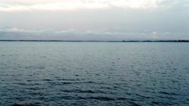 Deniz ve gökyüzünün önü şeffaf beyaz bulutlu parlak mavi renklerle. Sakinim, sakinim, rahatım.