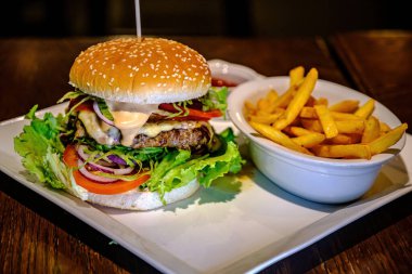 Etli, domatesli, peynirli, marullu ve patates kızartmalı lezzetli hamburgerler..