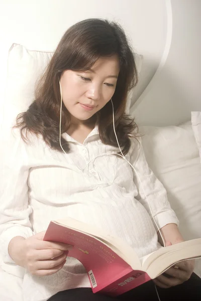 Asiatische schwangere Frau liest Buch — Stockfoto