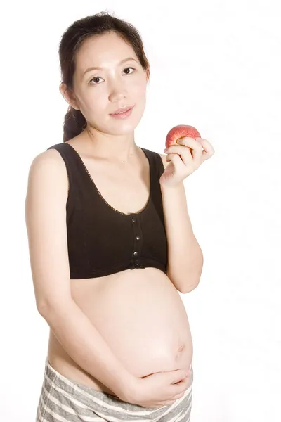 Ganska ung gravid kvinna äta äpple — Stockfoto