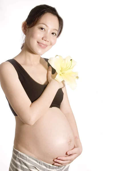 Pretty young pregnant woman with lily — Stock Photo, Image