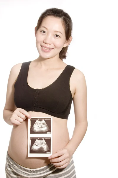 Pretty young pregnant woman holding her baby's B ultrasonic — Stock Photo, Image