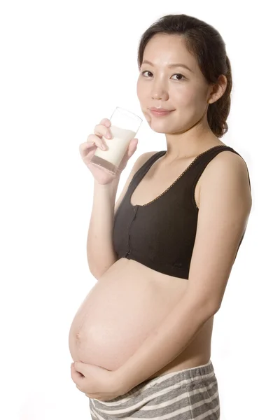 Jovem mulher grávida bebendo leite — Fotografia de Stock