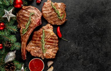 Baharatlı ızgara et ve siyah arka planda sebze.