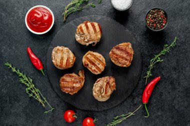 Siyah arka planda domatesli ızgara et ve biberiye. en üstteki görünüm.