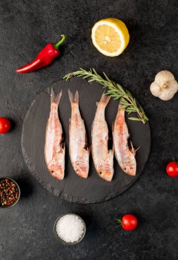 Limonlu ve biberiyeli çiğ somon. Siyah arka planda. en üstteki görünüm.