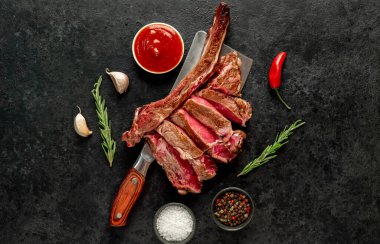 Siyah arka planda baharatlı ve otlu çiğ sığır kaburgası.