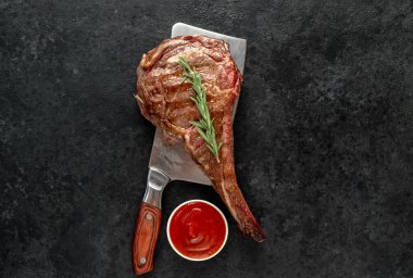 Baharatlı çiğ biftek ve siyah arka planda biberiye.