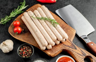 Biberiyeli çiğ tavuk eti ve ahşap tahtada otlar.