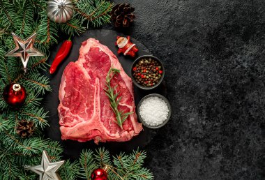 Baharatlı çiğ biftek ve siyah arka planda biberiye.