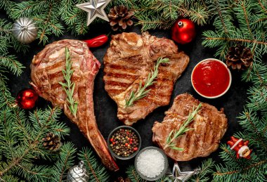 Siyah arka planda ızgara et, sebze ve baharat.